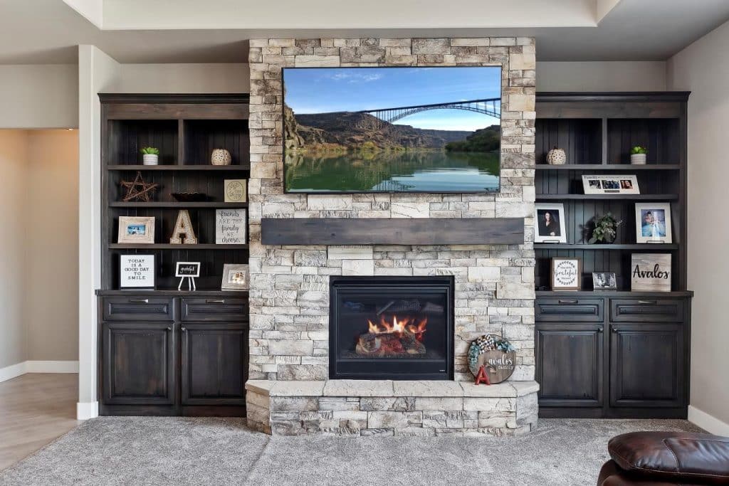 Natural stone fireplace with dark wood shelves