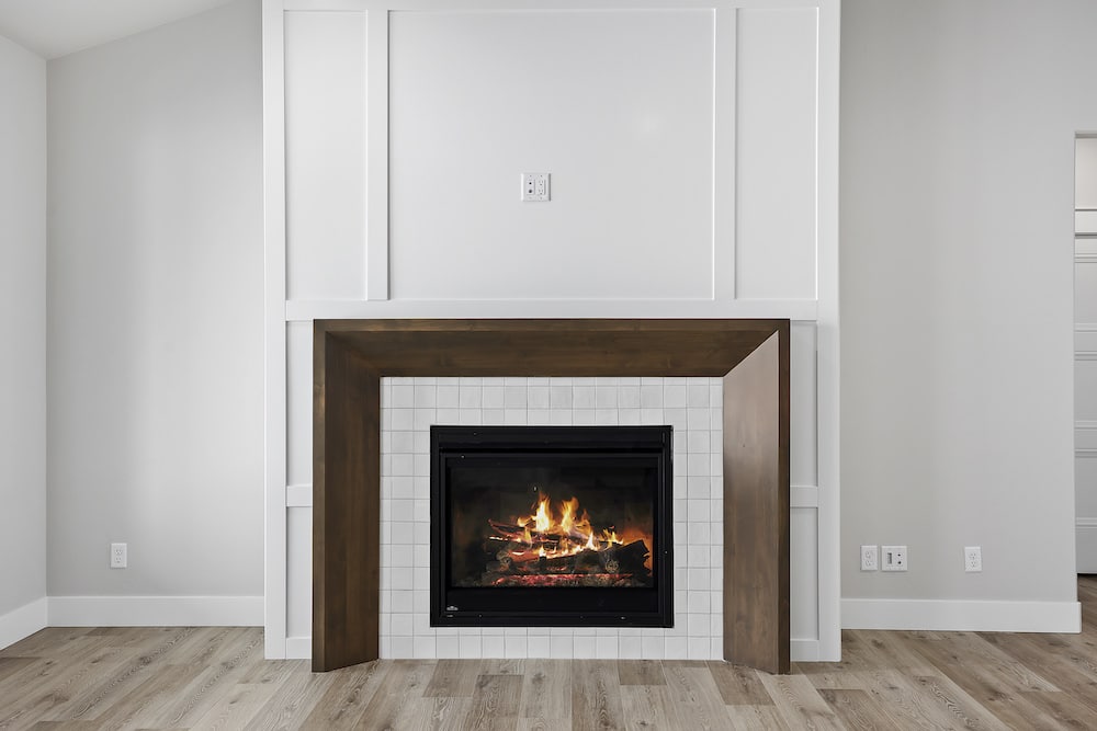 Large white fireplace with wood border
